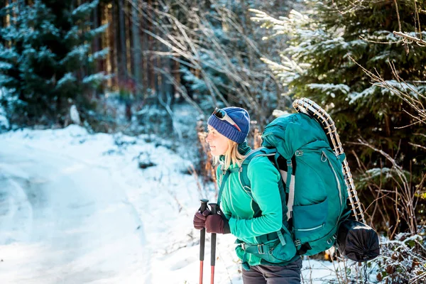 Vrouw met rugzak en sneeuwschoenen in de winter bergen. — Stockfoto