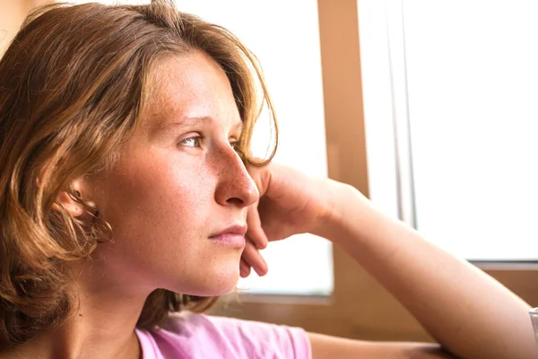 Portret van een vrouw in de buurt van het venster. — Stockfoto