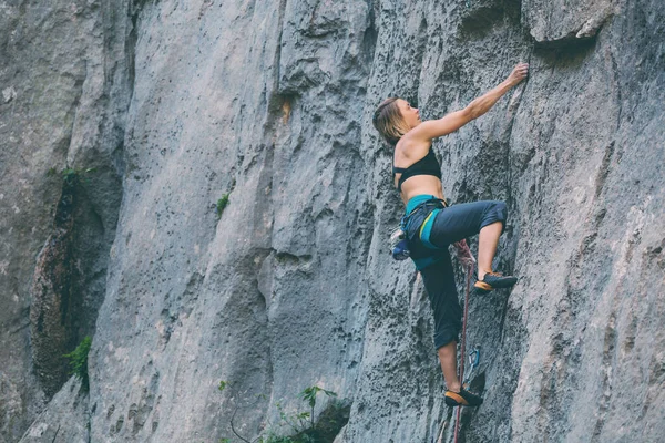 Una ragazza sale su una roccia . — Foto Stock