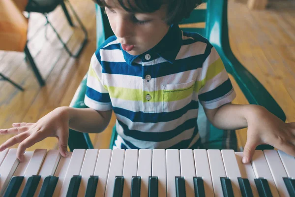 A child learns to play the piano. — Stock Photo, Image