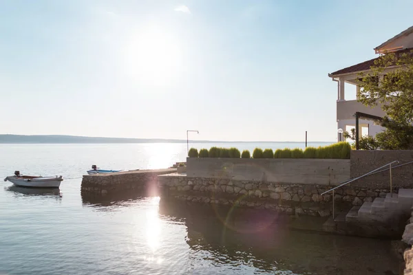 Boat on the pier near a large house with a terrace. — Stock Photo, Image