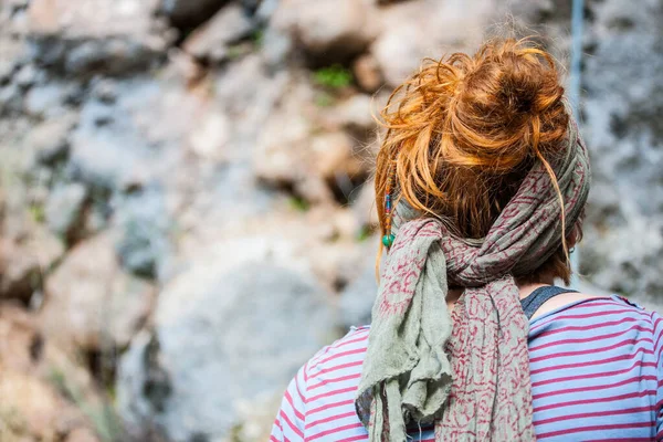 Red hair tied with a scarf.