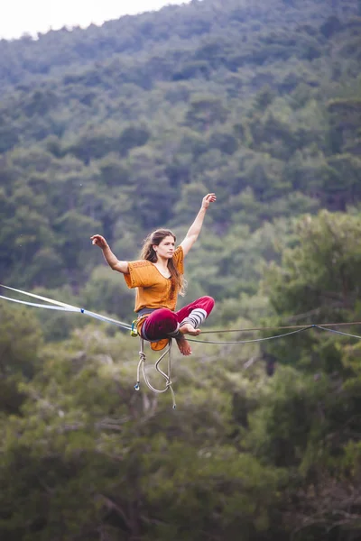 A woman catches balance on the line. — Stock Photo, Image