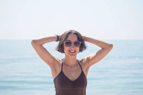 En leende kvinna står på stranden.. — Stockfoto