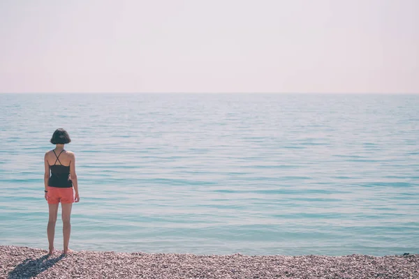 Chica delgada mira al mar . — Foto de Stock
