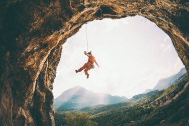 Kaya tırmanışçısı ipte sallanıyor. Bir kadın kemer şeklinde bir kayaya tırmanıyor. Kız mağaraya tırmanıyor. İpi bağlamak için tırmanma ipi. Türkiye 'de kaya tırmanışı .