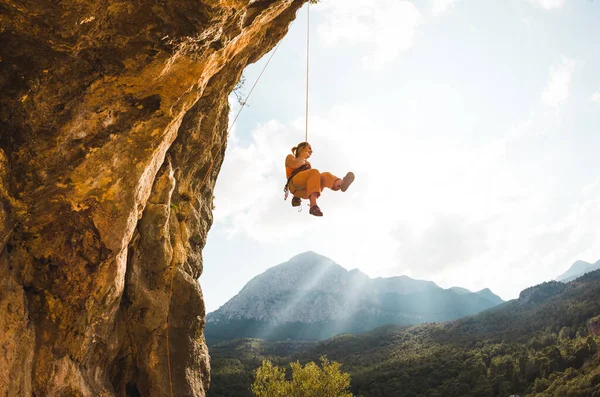 岩の登山ロープにかかっている 女性がアーチの形をした岩に登る 少女は洞窟に登る 裏切るためのロープを登る トルコのロッククライミング — ストック写真