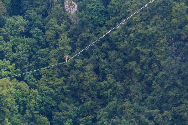 Bir Adam Gerilmiş Askı Boyunca Yürüyor Dağlarda Yüksek Bir Yer — Stok fotoğraf