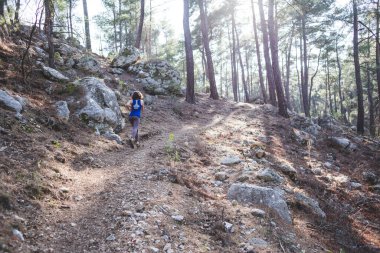 Bir kadın dağ yolunda koşuyor. Koşucu ormanda antrenman yapıyor. Parkta koşan bir kız. Skyrun.