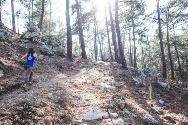 Bir kadın dağ yolunda koşuyor. Koşucu ormanda antrenman yapıyor. Parkta koşan bir kız. Skyrun.