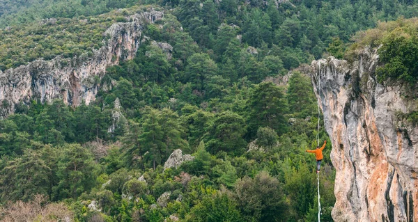 Bir Adam Gerilmiş Askı Boyunca Yürüyor Dağlarda Yüksek Bir Yer — Stok fotoğraf