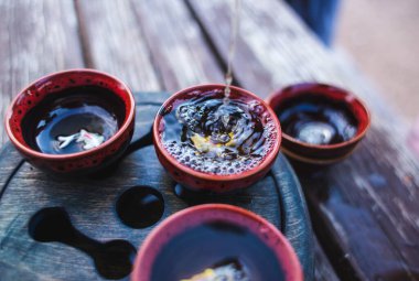 Çay seremonisi için. Çaydanlıktan bir fincana çay dökülür. Doğunun sanatı. Çay geleneği. 