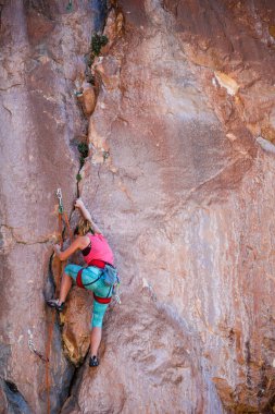 Bir kız kayaya tırmanıyor. Sporcu doğada antrenman yapar. Kadınlar zor tırmanış rotalarının üstesinden gelir. Güçlü bir dağcı. Olağanüstü bir hobi. Türkiye 'de kaya tırmanışı.