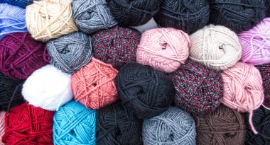 Renkli ipliğin arka planı. Toplar yakın plan çekimde. Dikiş işi için malzemeler. Dükkanda iplikle doldur. Örgü örmek için çok renkli iplikleri olan raflar.