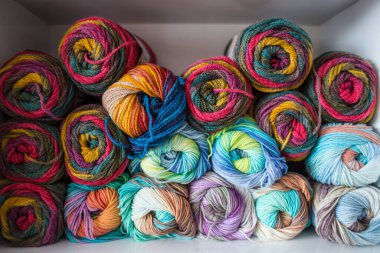 Renkli ipliğin arka planı. Toplar yakın plan çekimde. Dikiş işi için malzemeler. Dükkanda iplikle doldur. Örgü örmek için çok renkli iplikleri olan raflar.