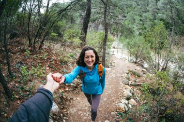 Sırt çantalı bir kadın sevgilisinin elini tutar. Resimli yerlerde birlikte seyahat etmek gibi. Bir kız ormanda yürüyor. Esmer kadın bir dağ yolunda..