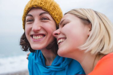 Mutlu eşcinsel çift dışarıda eğleniyor. Genç kadınların randevusu var. Eşitlik hakkı, homoseksüellik yaşam tarzı, lgbt ve ilişki konsepti. İki gülümseyen kız sahilde birbirlerine sarılırlar..