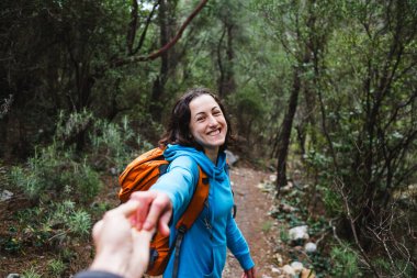Sırt çantalı bir kadın sevgilisinin elini tutar. Resimli yerlerde birlikte seyahat etmek gibi. Bir kız ormanda yürüyor. Esmer kadın bir dağ yolunda..