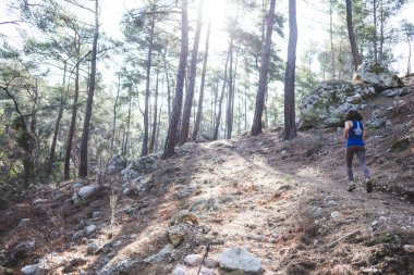 Bir kadın dağ yolunda koşuyor. Koşucu ormanda antrenman yapıyor. Parkta koşan bir kız. Skyrun.