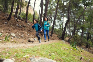 Bir kadın çocuğuyla orman yolunda koşar, çocuk annesinden kaçar, bir kadın oğluyla doğada vakit geçirir, parkta yürür..