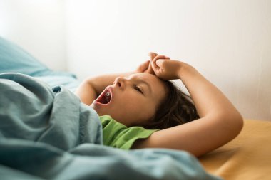 Çocuk yatakta uzanırken esniyor, çocuk uyanırken esniyor, Uykucu bebek, çocuk uykuya dalıyor, Sabah Uyanışı.