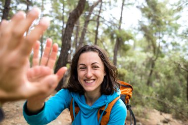 Sırt çantalı bir kadın, dağların ve ormanın arka planında seyahat eden bir arkadaşına beş dolar veriyor, Türkiye 'nin pitoresk yerlerine seyahat ediyor, selamlama hareketi yapıyor..