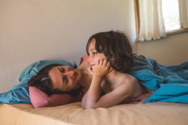 Annesiyle yatan bir çocuk, oğluyla evde vakit geçiren bir kadın, bir çocukla tembel bir hafta sonu, annesiyle bebek portresi....