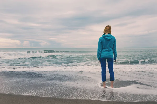 Una Chica Está Parada Una Playa Arena Una Mujer Está — Foto de Stock