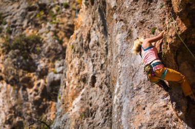 Bir kız kayaya tırmanıyor. Sporcu doğada antrenman yapar. Kadınlar zor tırmanış rotalarının üstesinden gelir. Güçlü bir dağcı. Olağanüstü bir hobi. Türkiye 'de kaya tırmanışı.