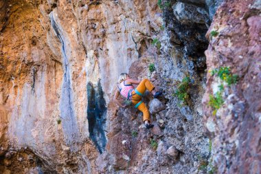 Bir kız kayaya tırmanıyor. Sporcu doğada antrenman yapar. Kadınlar zor tırmanış rotalarının üstesinden gelir. Güçlü bir dağcı. Olağanüstü bir hobi. Türkiye 'de kaya tırmanışı.