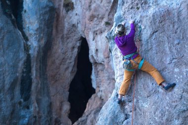Bir kız kayaya tırmanıyor. Sporcu doğada antrenman yapar. Kadınlar zor tırmanış rotalarının üstesinden gelir. Güçlü bir dağcı. Olağanüstü bir hobi. Türkiye 'de kaya tırmanışı.