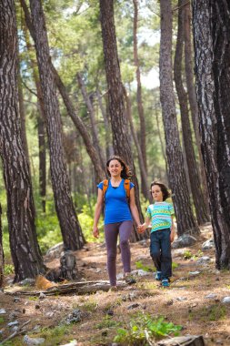 Bir kadın oğluyla ormanda yürür, annesiyle yürüyüşe çıkar, sırt çantalı bir çocuk parka gider, çocuklarla seyahat eder, çocuk annesinin elini tutar, dağ yolu, Anneler Günü..