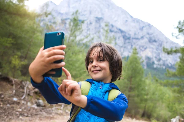 Menino Com Uma Mochila Faz Selfie Smartphone Fundo Belas Montanhas — Fotografia de Stock