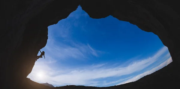 모양의 바위를 오르는 등산가 실루엣 하늘을 배경으로 동굴을 오르는 — 스톡 사진