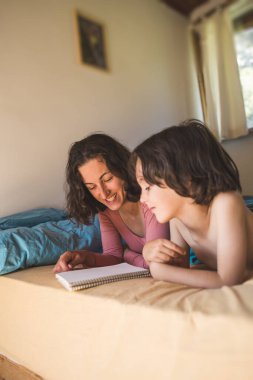 Annesiyle yatakta yatan ve kitap okuyan bir çocuk, evde oğluyla vakit geçiren bir kadın, bir çocukla tembel bir hafta sonu, annesiyle birlikte yürümekte olan bir çocuğun portresi, anne karantina sırasında çocuğu eğlendiriyor..