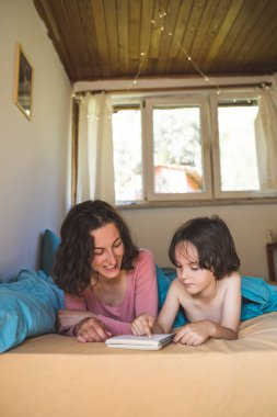 Annesiyle yatakta yatan ve kitap okuyan bir çocuk, evde oğluyla vakit geçiren bir kadın, bir çocukla tembel bir hafta sonu, annesiyle birlikte yürümekte olan bir çocuğun portresi, anne karantina sırasında çocuğu eğlendiriyor..