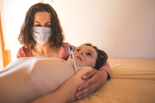 Uma Mulher Com Uma Máscara Protetora Mede Temperatura Criança Chame — Fotografia de Stock