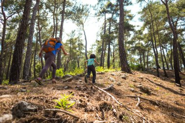 Bir kadın çocuğuyla orman yolunda koşar, çocuk annesinden kaçar, bir kadın oğluyla doğada vakit geçirir, parkta yürür..