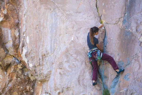 A strong girl climbs a rock, Rock climbing in Turkey, Training endurance and strength, Woman in extreme sport, Rock climber is training in nature.