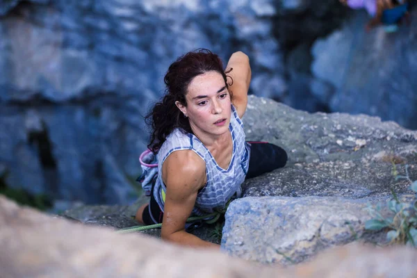 A woman is climbing in Turkey, Turkish woman climbs the rock, Extreme hobby, Overcoming a difficult climbing route, Overcoming the fear of heights, Climbing effort.