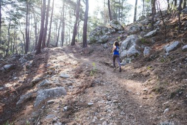 Bir kadın dağ yolunda koşuyor. Koşucu ormanda antrenman yapıyor. Parkta koşan bir kız. Skyrun.
