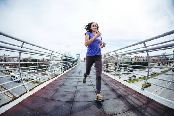 一个女人穿过了马路对面的桥 在城市里进行训练女孩训练耐力 实现这个目标 城市景观 — 图库照片