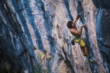 Güçlü bir adam kayaya tırmanır, güçlü sırt kasları, Türkiye 'de kaya tırmanışı, dayanıklılık ve güç eğitimi alır, ekstrem sporlarda çalışan bir adam, dağcı doğada eğitim görür..