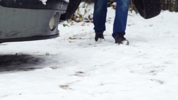 Tiro de pés de um homem que traz pneus de neve — Vídeo de Stock