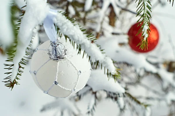 Palle di Natale su rami di abete rosso ricoperti di neve all'aperto — Foto Stock