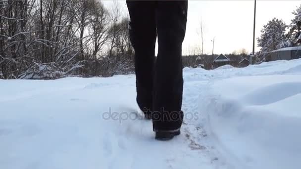 Man lopen langs besneeuwde weg op platteland — Stockvideo