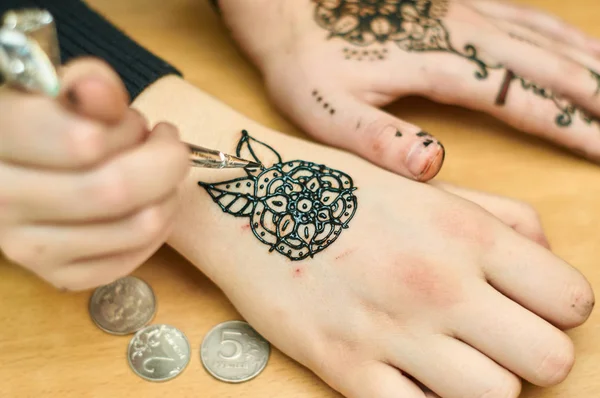 Chica dotada dibuja patrones por henna en las manos — Foto de Stock