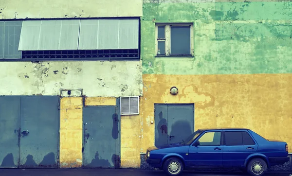 Vintage auto stojící u zdi zchátralého domu — Stock fotografie