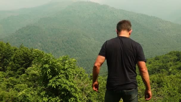 Feliz hombre extendiendo los brazos en las montañas — Vídeo de stock