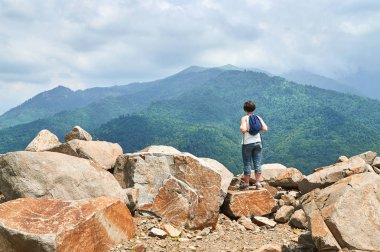 Orta yaşlı bir kadın dağ manzarasından hoşlanıyor.